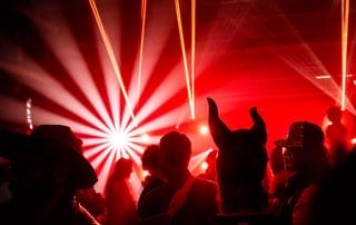 Crowd enjoying the vibrant red lighting and laser effects at the Halloween event in Denver.