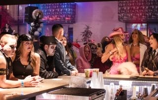 Costumed guests mingling at the bar, with a mix of spooky and glamorous outfits during the Halloween event.