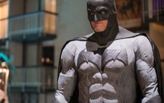 Batman costume worn by a participant at the Paranormal Palace event, with hotel balconies visible in the background.